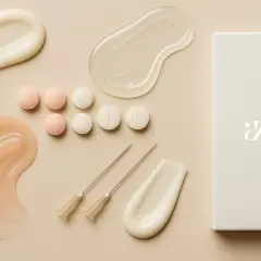 Kosmetolog dobór pielęgnacji: próbki kremów, serum, tabletki i igły do mezoterapii.