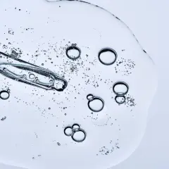 Kropla serum z pipetką, bąbelki unoszące się w żelu. Czy peptydy można łączyć z witaminą C? To pytanie nurtuje wiele osób dbających o cerę.