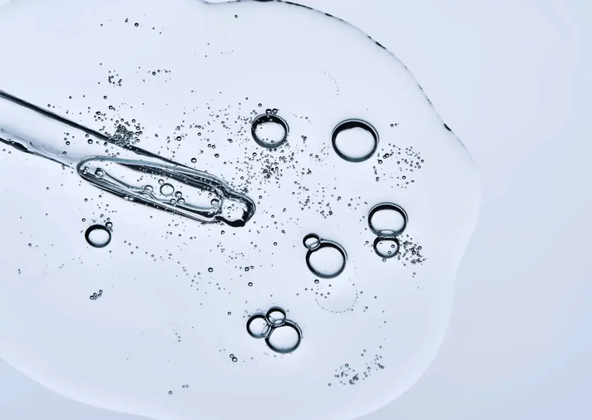 Kropla serum z pipetką, bąbelki unoszące się w żelu. Czy peptydy można łączyć z witaminą C? To pytanie nurtuje wiele osób dbających o cerę.
